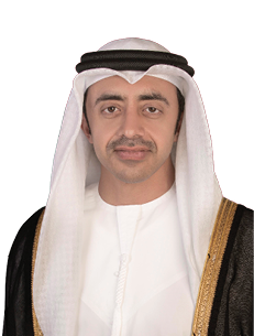 شخص يرتدي زيًا تقليديًا عربيًا أبيض مع عباءة سوداء مزينة بحواف ذهبية وغطاء رأس أبيض مع شريط أسود. Description generated by AI