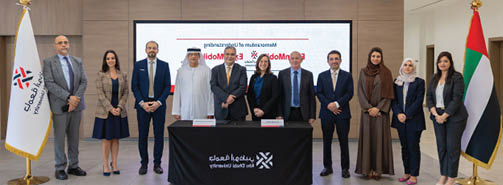 مبنى حديث بتصميم معماري مستقبلي بأشكال منحنية وزجاجية محاط بمنطقة حضرية واسعة ومسطحات خضراء. Description generated by AI